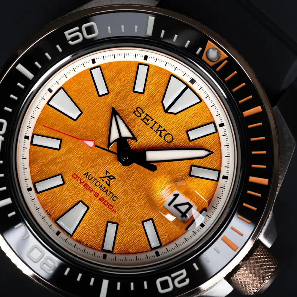 Close-up of Seiko Prospex HBB005K1 amber tiger-stripe dial with Lumibrite markers and date window
